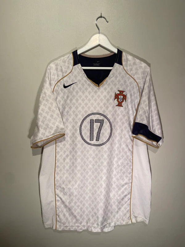 02A18988-9566-4C4B-8C83-0493B941270F | AE JERSEY Portugal national team white soccer jersey with gold piping and crest on the left chest, hanging on a hanger.