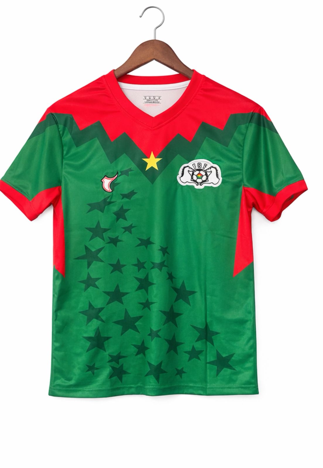 05a30315-077d-476b-8d9e-4ca7fd1fba2c | AE JERSEY Green and red V-neck sports jersey on a wooden hanger, featuring a star pattern across the front and a crest on the chest.