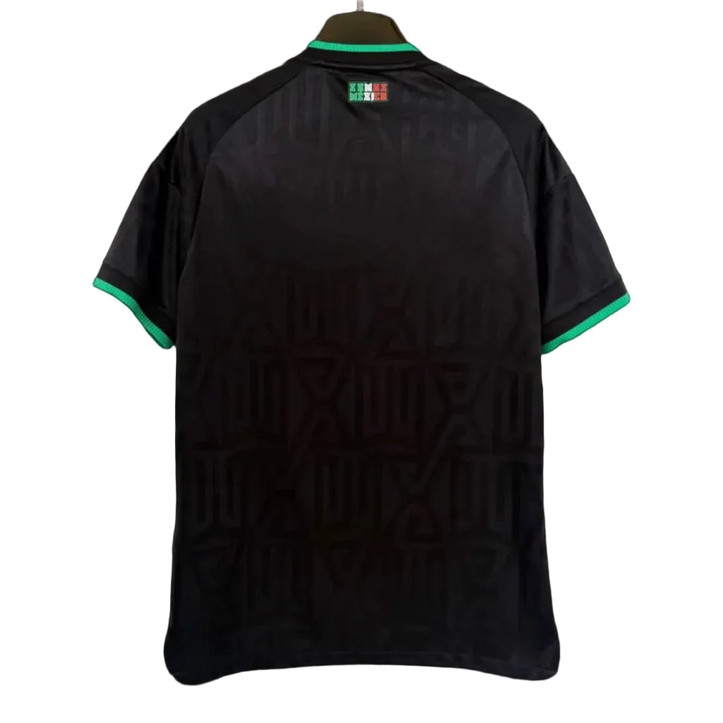 0805a718-1024x1024-1 | AE JERSEY Back view of a black short-sleeve shirt on a hanger, with green trim at the collar and cuffs and a subtle geometric pattern on the fabric.