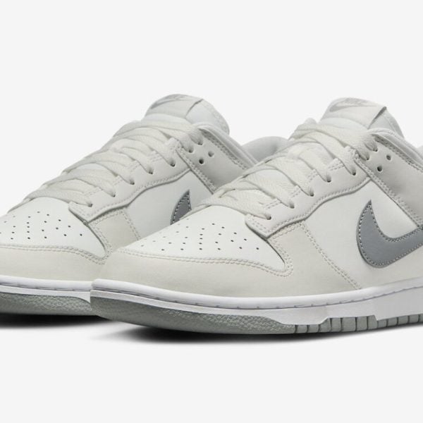 White Nike sneakers with a light gray swoosh and gray sole, low-top design.