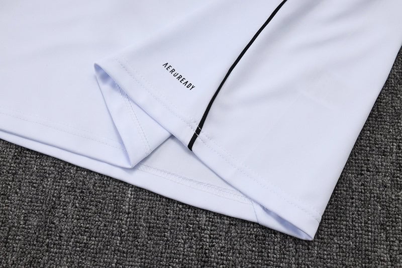 0921961e | AE JERSEY Close-up of a light lavender shirt sleeve laid on a gray carpet, showing the 'NEVER READY' branding near the cuff.
