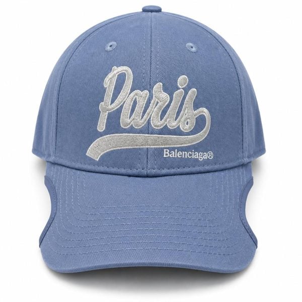 Blue baseball cap with white embroidered 'Paris' script and 'Balenciaga' logo on the front panel; curved brim and structured crown.