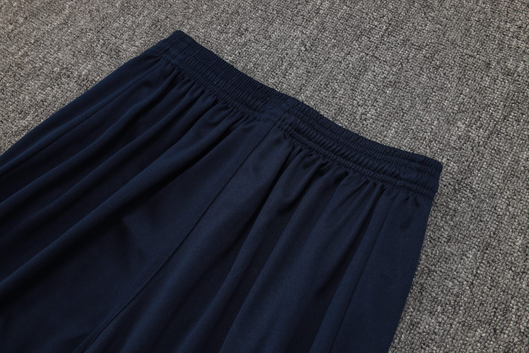 0b26cbaa | AE JERSEY Navy blue elastic-waist skirt laid flat on a gray carpet.
