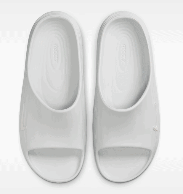 1111_a0a5f2a4-9661-4023-a292-d5af7ce08dad | AE JERSEY Pair of white open-toe slide slippers viewed from above, top-down perspective.