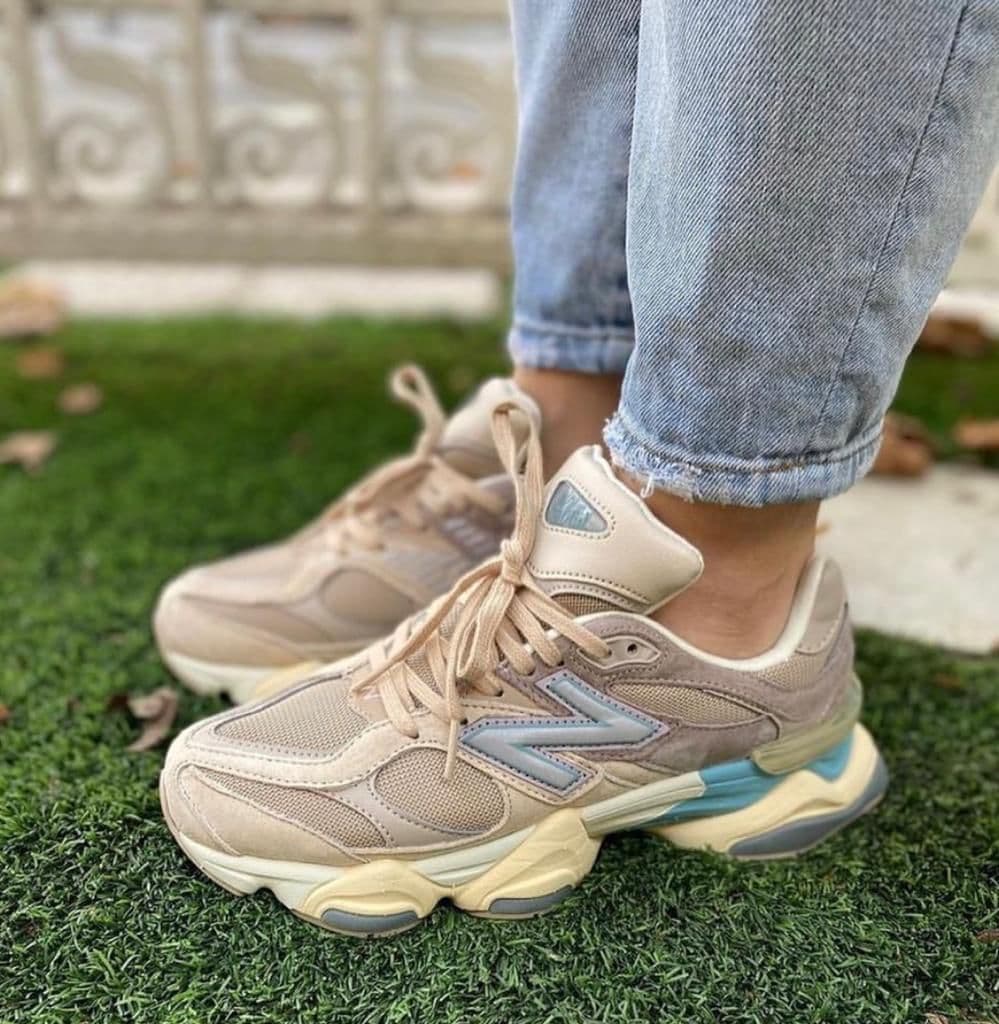 15a29329-b1d8-47c8-ae01-d81e212dd97e_6096093d-9747-4982-8d81-d7f9bca11ce2 | AE JERSEY Beige chunky sneakers on a person standing on artificial grass, jeans cuffs rolled up.
