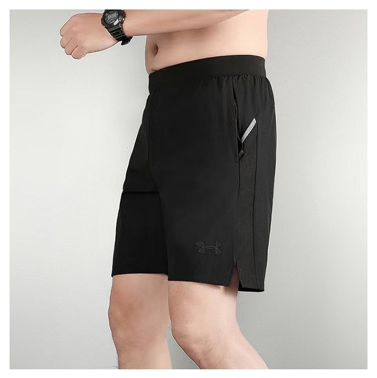17297e3c | AE JERSEY Model wearing black athletic shorts with a zippered side pocket and a small Under Armour logo, shown in a side view.
