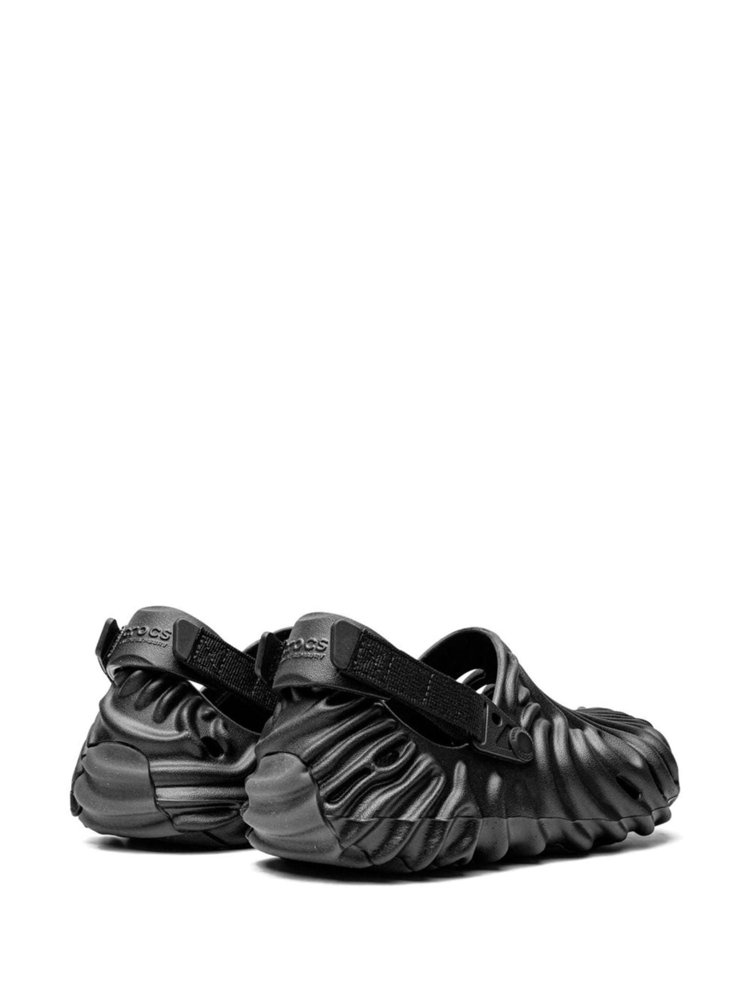 19201488_42049979_2048 | AE JERSEY Black rugged sandals with thick, wavy straps and buckles on a white background (product photo).