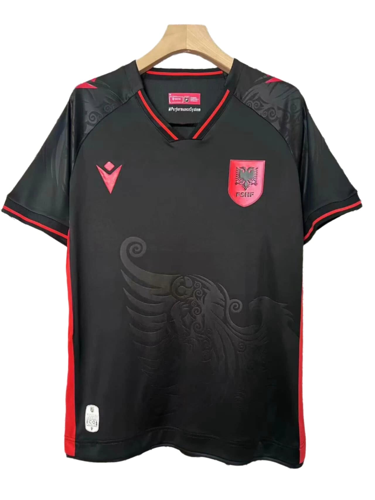 1ac8aee3 | AE JERSEY Black soccer jersey on a hanger with red trim and crest, featuring a red shield with a double-headed eagle on the chest.