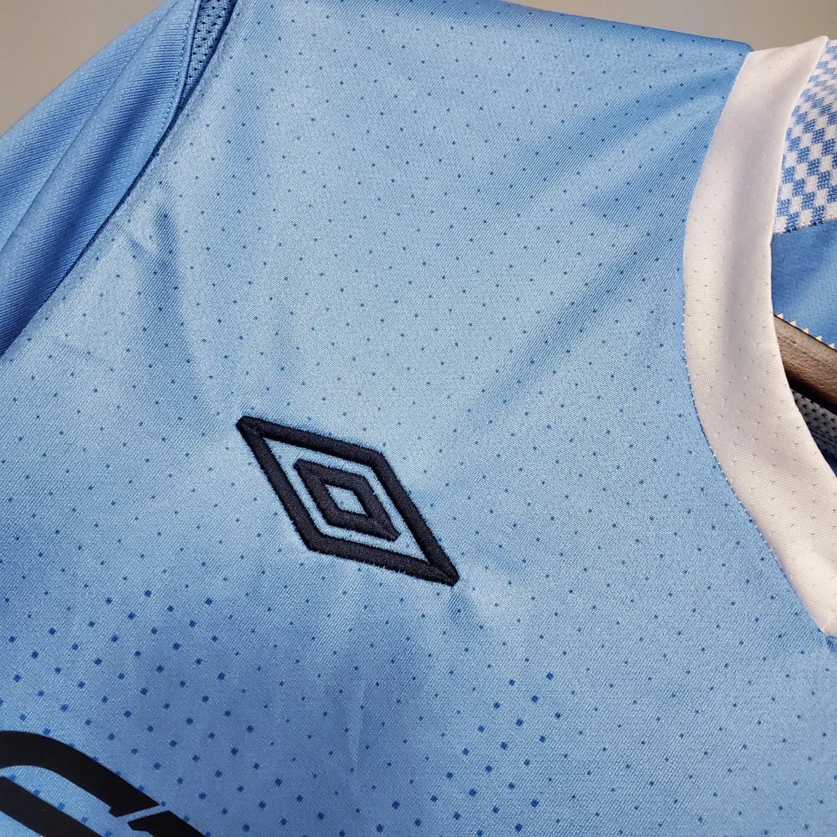 2012-Manchester-City-Retro-Home-Short-Sleeve-Jersey4 | AE JERSEY Light blue sports jersey fabric with a dark blue double-diamond Umbro logo on the chest area.
