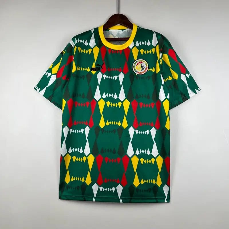 2023-Senegal-Soccer-Jersey-Home-4 | AE JERSEY Green sports jersey with a bright yellow collar featuring a bold geometric pattern in red, yellow, white, and dark green; circular club badge on the chest.