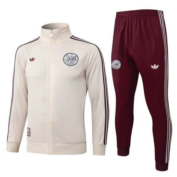 Beige Adidas zip-up track jacket with navy stripes and crest, paired with burgundy track pants with white side stripes and logos.