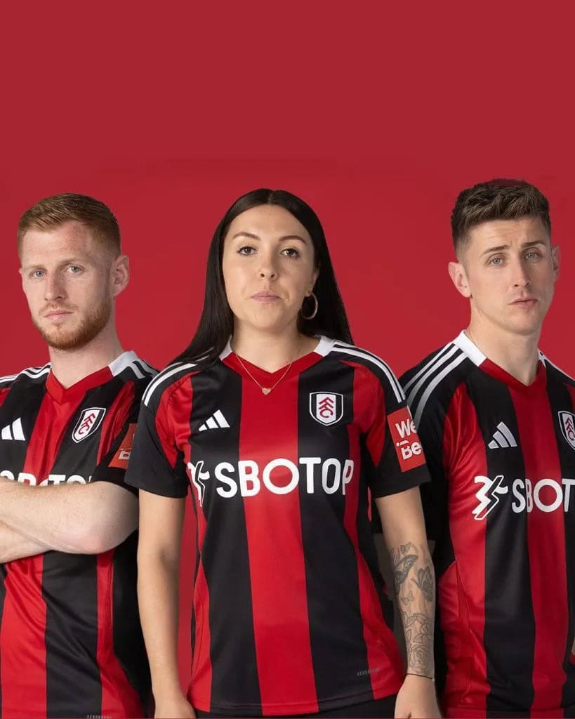 2wrwefr | AE JERSEY Three soccer players in red-and-black striped jerseys stand against a red background, facing the camera.
