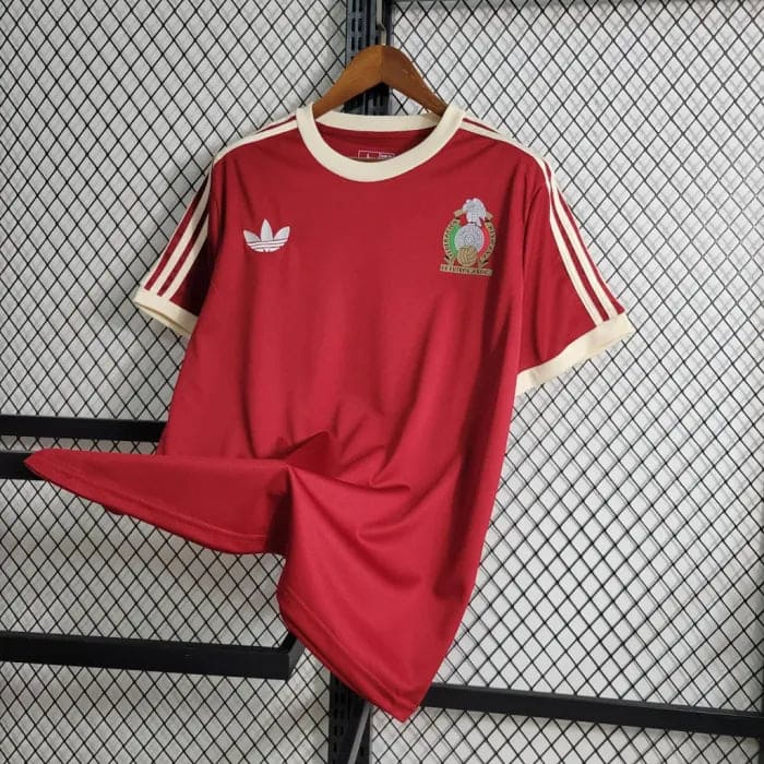 35d9ce34231dce3a_a4dfb13e-ef31-427d-aa7e-6b1bc255373e | AE JERSEY Red Adidas short-sleeve football jersey on a hanger, white collar and sleeve trim, with a crest on the left chest and Adidas trefoil on the right chest area.