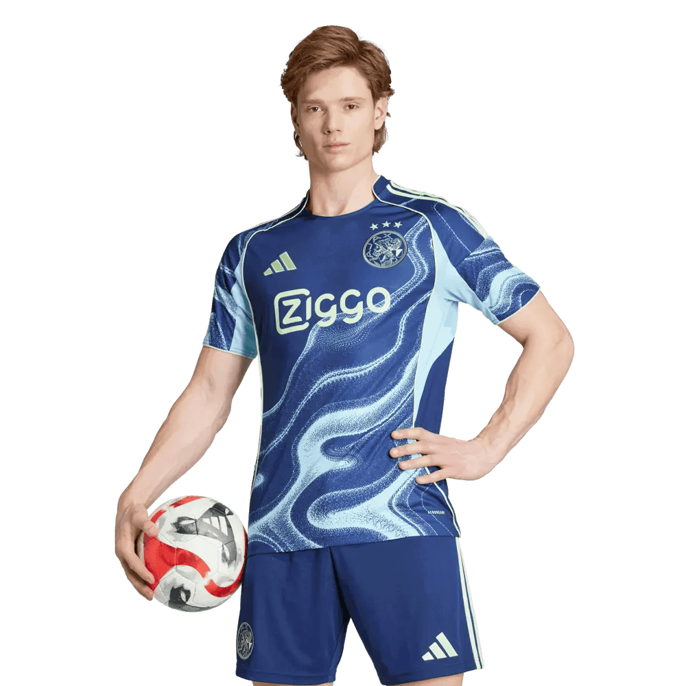 37dddf33-9fd3-7cc6-86d2-266725cd3f01 | AE JERSEY Soccer player in a blue uniform posing with a soccer ball against a green background.