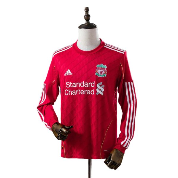Red Liverpool FC training jersey on a mannequin, featuring the Standard Chartered sponsor and Adidas logo with white stripes on the shoulders and sleeves.