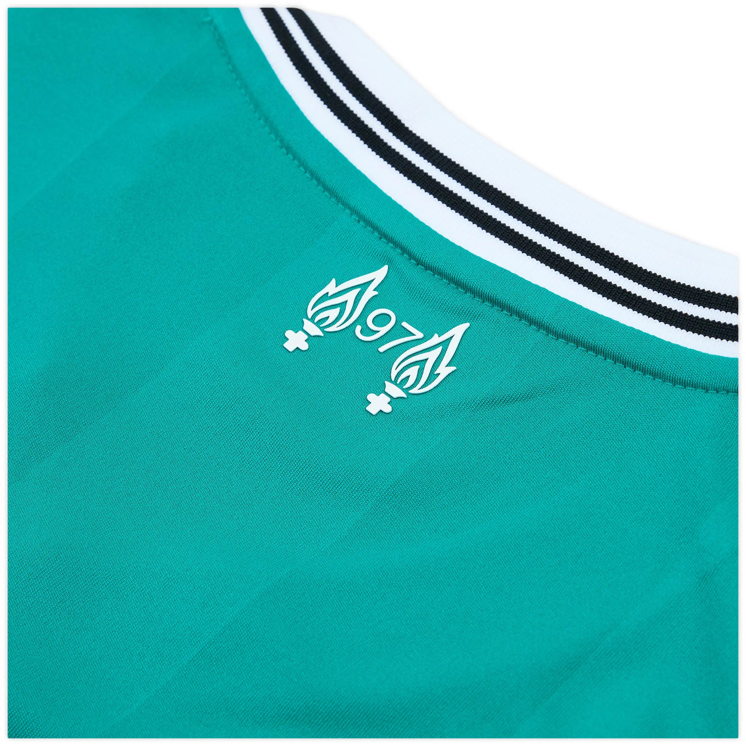 4068809557572-4_4cw0rd3gsjfv8xqu | AE JERSEY Partial close-up of a teal sneaker, showing teal fabric and a white midsole with two black stripes along the edge.