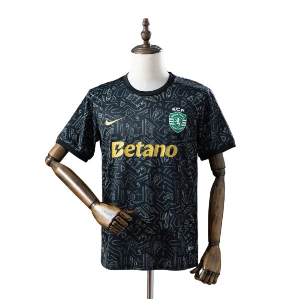 Black patterned soccer jersey on a mannequin with Betano sponsor and Sporting CP crest on the chest, short sleeves and gold logo detail.