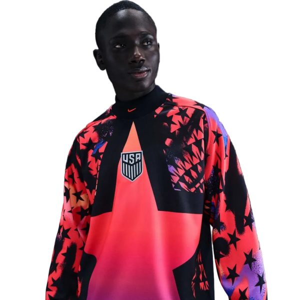 Young man wearing a vibrant pink and black USA team jersey with star patterns and a crest on the chest.
