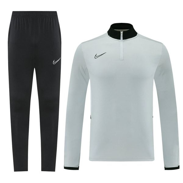 Nike black jogger pants paired with a light gray quarter-zip training top featuring a black collar and Nike swoosh logo on each piece.