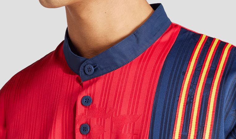 5434504f-4e13-412a-9ab6-3603cd9de1ae | AE JERSEY Close-up of a red kurta with a dark blue mandarin collar and blue buttons; multicolored vertical stripes along the side.