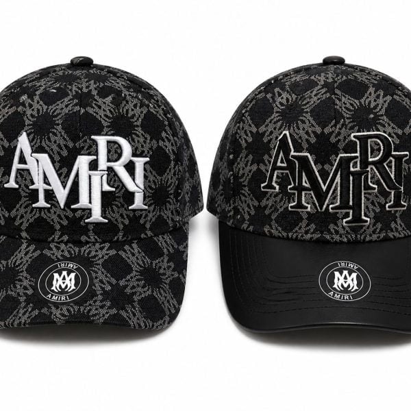 Two black caps with a gray jacquard pattern and AMIRI branding, one with solid white 'AMIRI' embroidery and the other with outlined embroidery on the front panels.