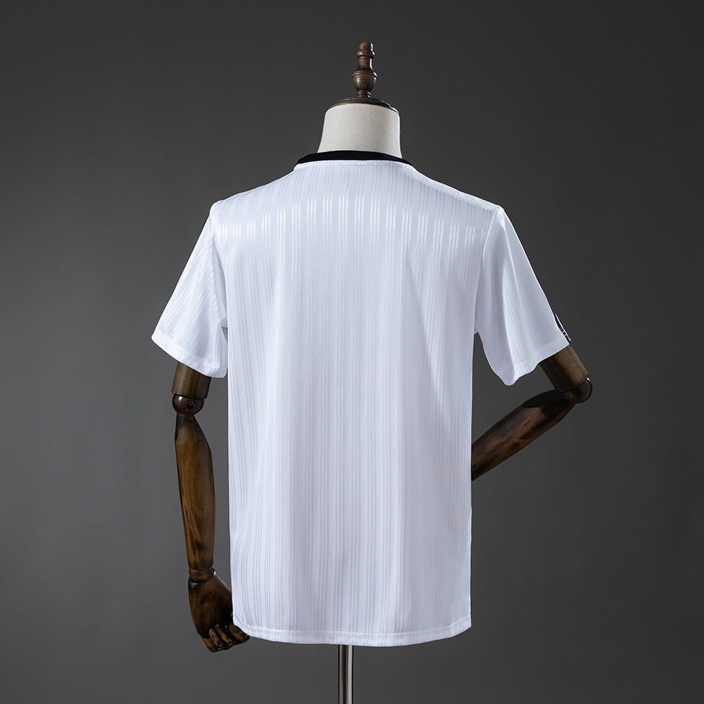 57f6aa44 | AE JERSEY Back view of a white short-sleeve polo shirt with subtle vertical stripes on a mannequin against a dark background, showing the garment's fit and collar detail.