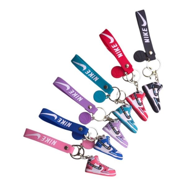 Nike-branded keychains with colorful miniature sneaker charms and matching wrist straps photographed diagonally.