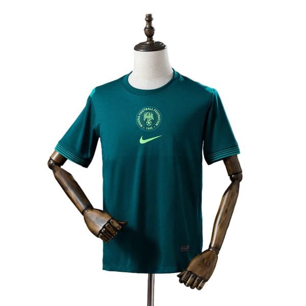 Teal football jersey on a mannequin, featuring a circular crest and a lime Nike swoosh.