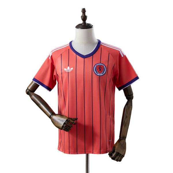 61fd3688 | AE JERSEY Red Scotland football jersey on a mannequin, red with navy vertical pinstripes, purple trim at collar and sleeves, crest on left chest and Adidas logo on the right.