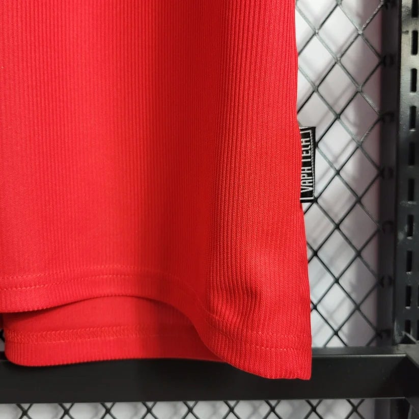 6_0b69a21e-4f44-4542-bd14-8a1859d16a92 | AE JERSEY Close-up of bright red fabric hanging on a clothing rack, with a small black tag visible on the side.