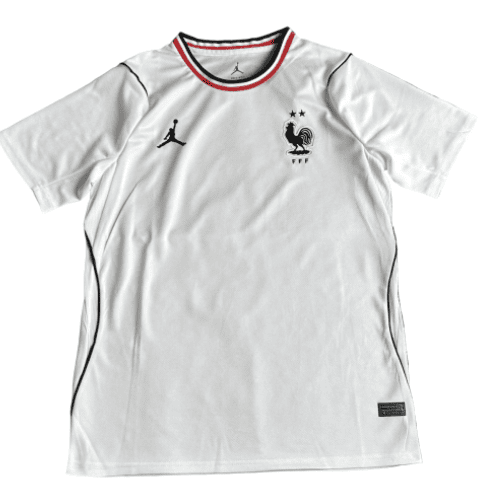 Front view of a white France national team soccer jersey with rooster crest, two stars above, red-and-black collar trim, and brand logos.