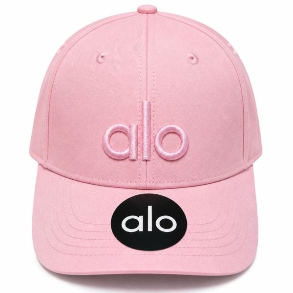 Pink baseball cap with pink embroidered 'alo' logo on the front and a black 'alo' sticker on the brim.