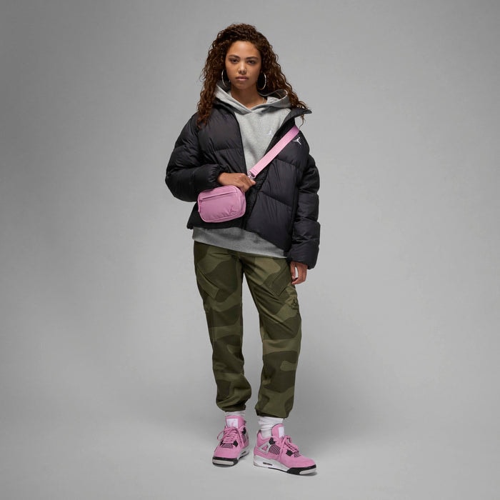 78d51463_77c1_4b58_973d_d04b69150c81 | AE JERSEY Woman wearing a black puffer jacket over a gray hoodie, camouflage cargo pants, pink sneakers, and a pink crossbody bag in a neutral studio setting.