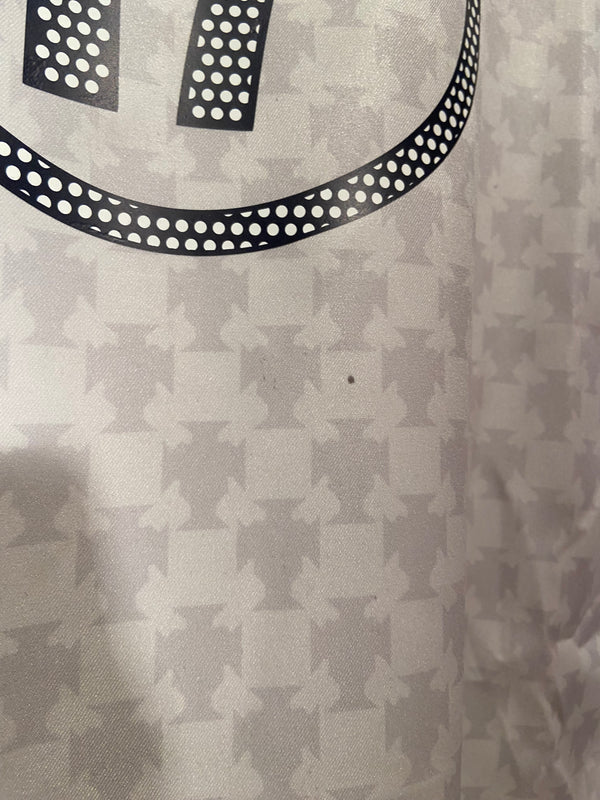 7C055882-84F8-4C35-A1E3-7A3477AF8B09 | AE JERSEY Close-up of light gray fabric with a repeating geometric pattern and a partial black dotted curved stripe.
