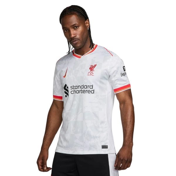 Male model wearing Liverpool FC white away jersey with red trim, crest, Nike logo, and Standard Chartered sponsor.