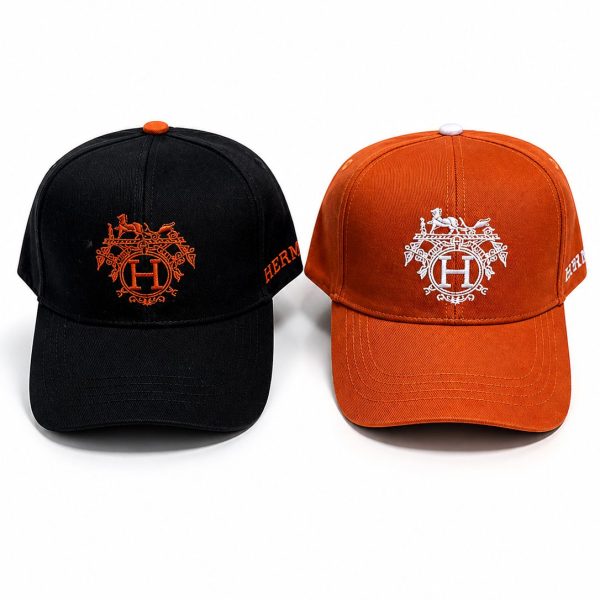 Two baseball caps side by side, one black and one orange, each with an ornate crest and a prominent 'H' embroidery on the front.