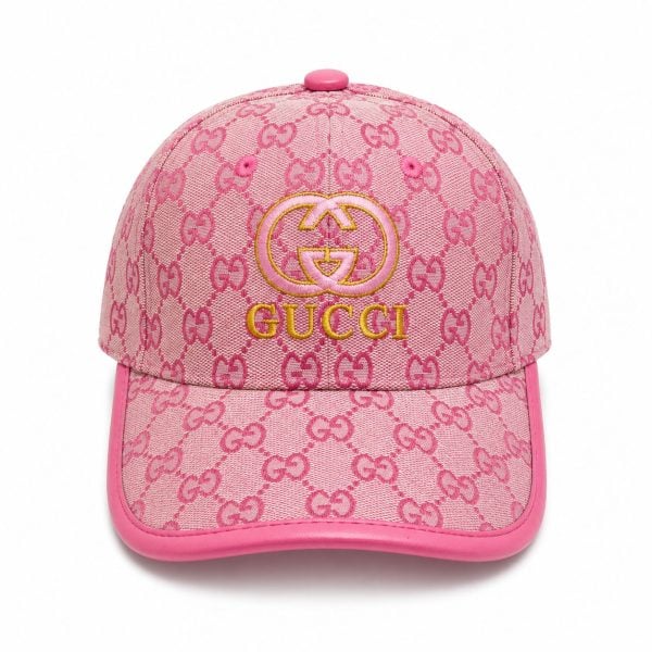 Pink Gucci baseball cap with a repeating GG monogram and a gold-embroidered Gucci logo on the front, pink trim included.
