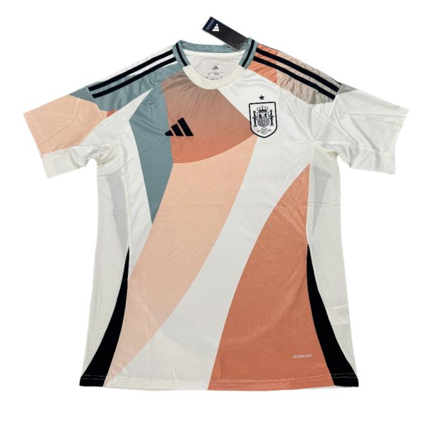 White soccer jersey with peach and teal geometric panels, Adidas logo, and national crest on the chest.