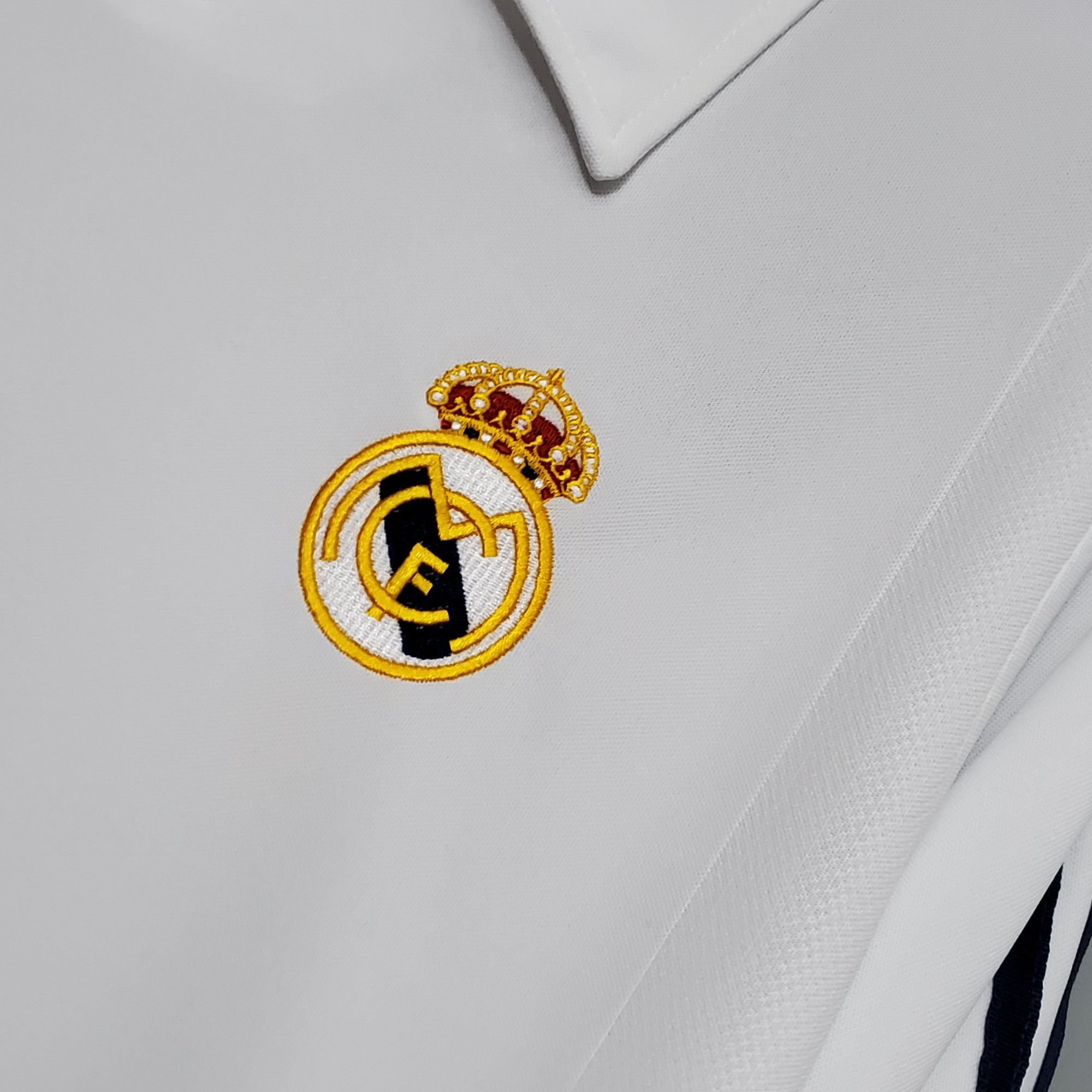 865ff37b_cae6167b-46de-4379-a5e6-7040acf4aca3 | AE JERSEY Partial Real Madrid crest embroidered on white fabric.