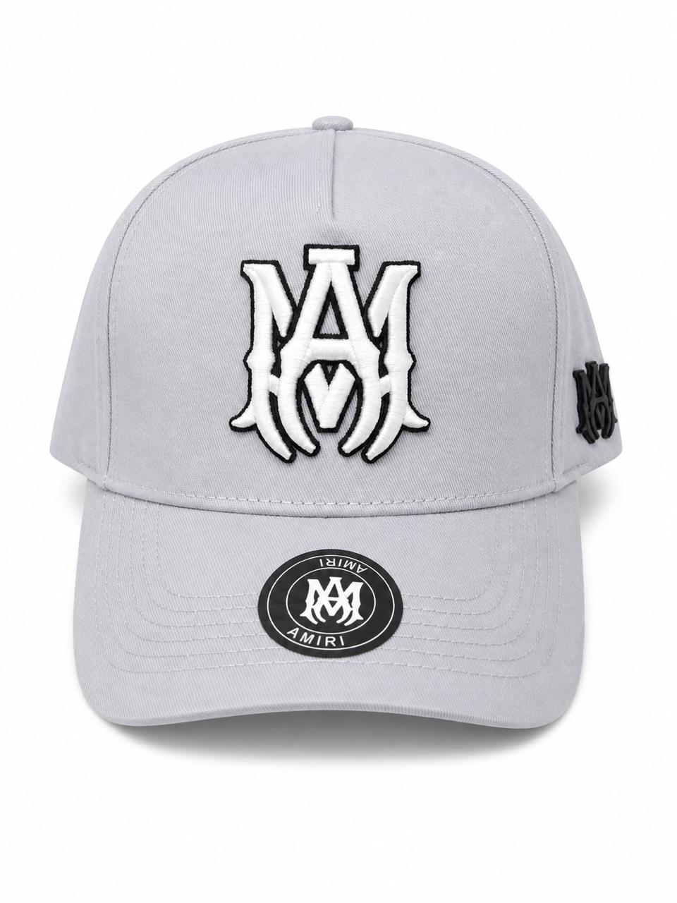 87c2cc9a-f439-47c4-9213-1d2f91a6ea66 | AE JERSEY Gray baseball cap with a large white embroidered AM logo on the front and a small side patch; circular sticker on the brim.