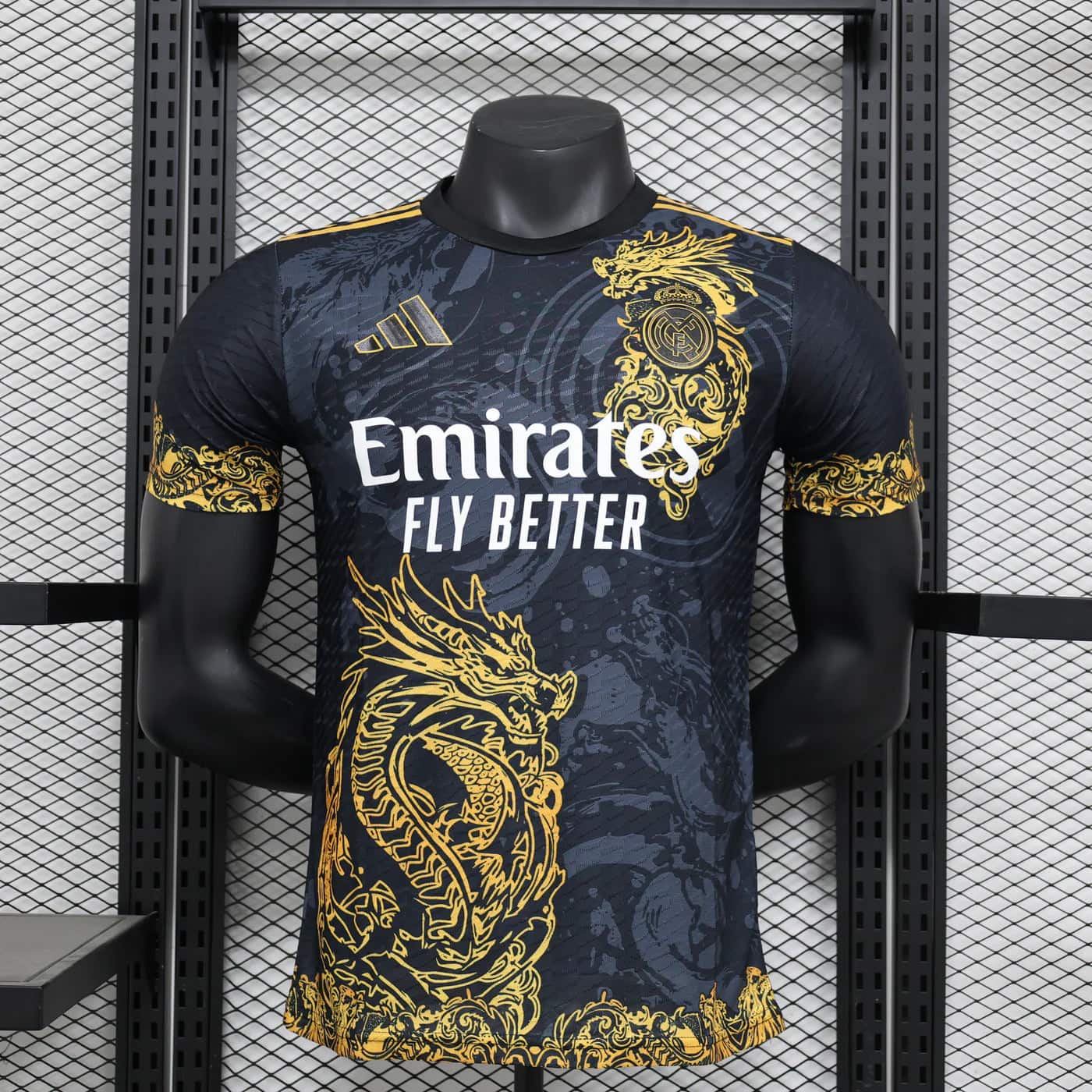 891692c3 | AE JERSEY Real Madrid soccer jersey on a mannequin with gold dragon patterns and the Emirates Fly Better sponsor text.