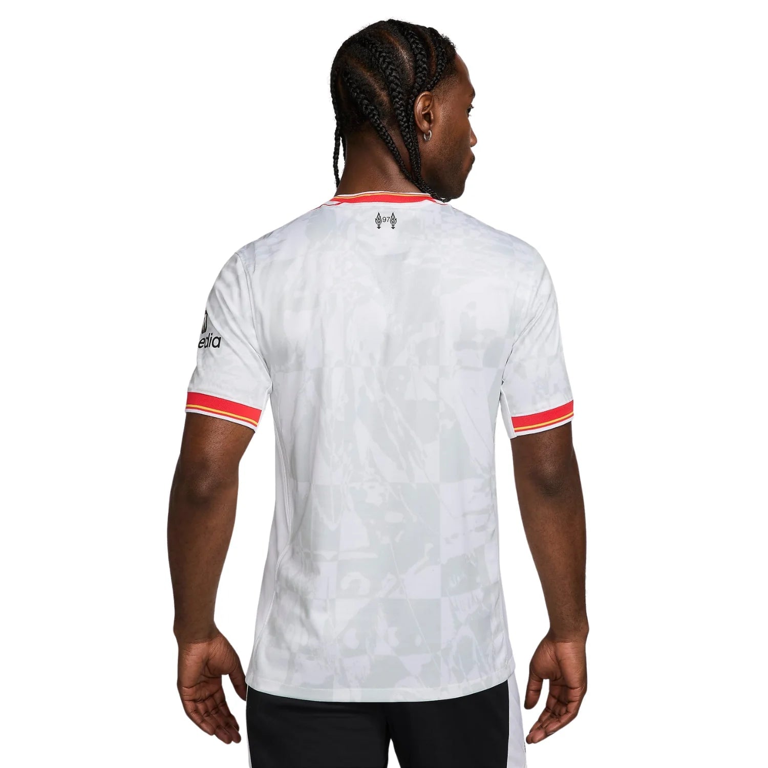 8_5c637b19-97b1-4ea9-af32-27e4a9575c1a | AE JERSEY Back view of a white sports jersey with red and yellow striped sleeve cuffs and a small logo near the neckline, worn by a man with braided hair.