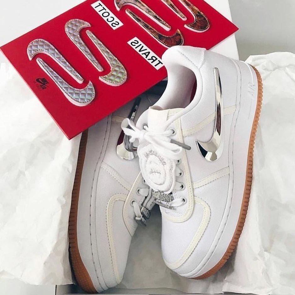 8d4eb639-78a0-43f5-b596-08b44bf40848_fe806772-ce1e-4ac0-a878-a378a1c263b0 | AE JERSEY White high-top sneakers with metallic silver accents, placed on white tissue with a red display card nearby.