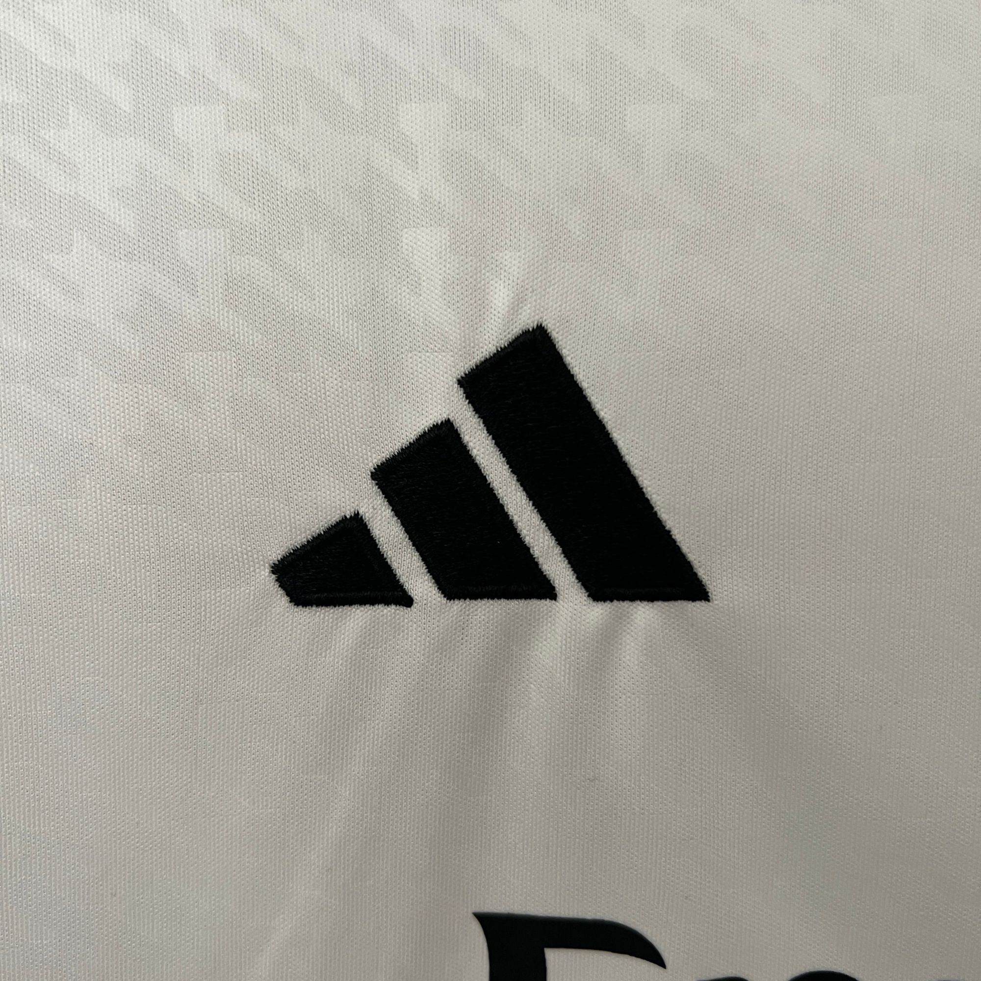 8e8e3fe3 | AE JERSEY Close-up of a light gray knit fabric with a bold black diagonal stripe/pattern at the bottom edge.