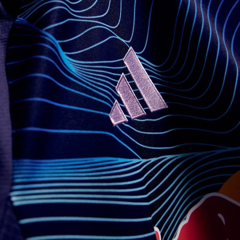 AOyjTXtAUVIf8TG | AE JERSEY Close-up of a blue sports jersey with a white Adidas logo and wavy line pattern in the fabric design.