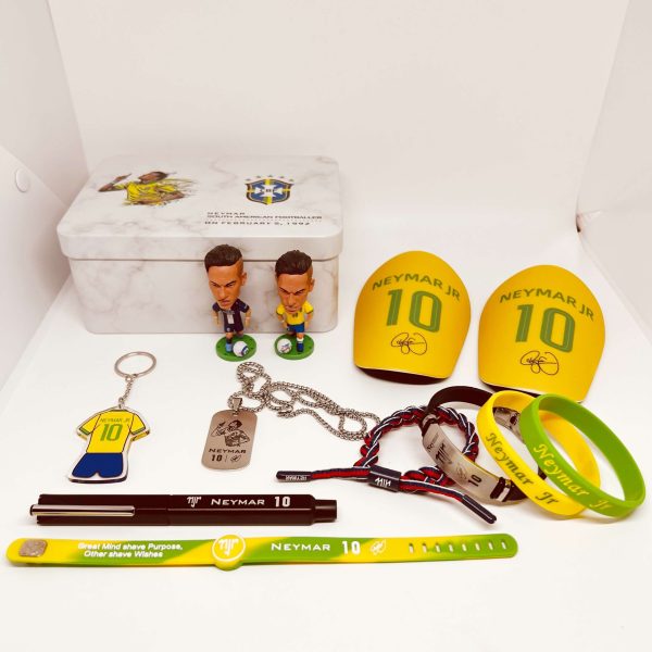 Neymar Jr. memorabilia laid out: yellow number-10 armbands, two figurines, keychain, dog tag, bracelets, and a Brazil crest tin box.