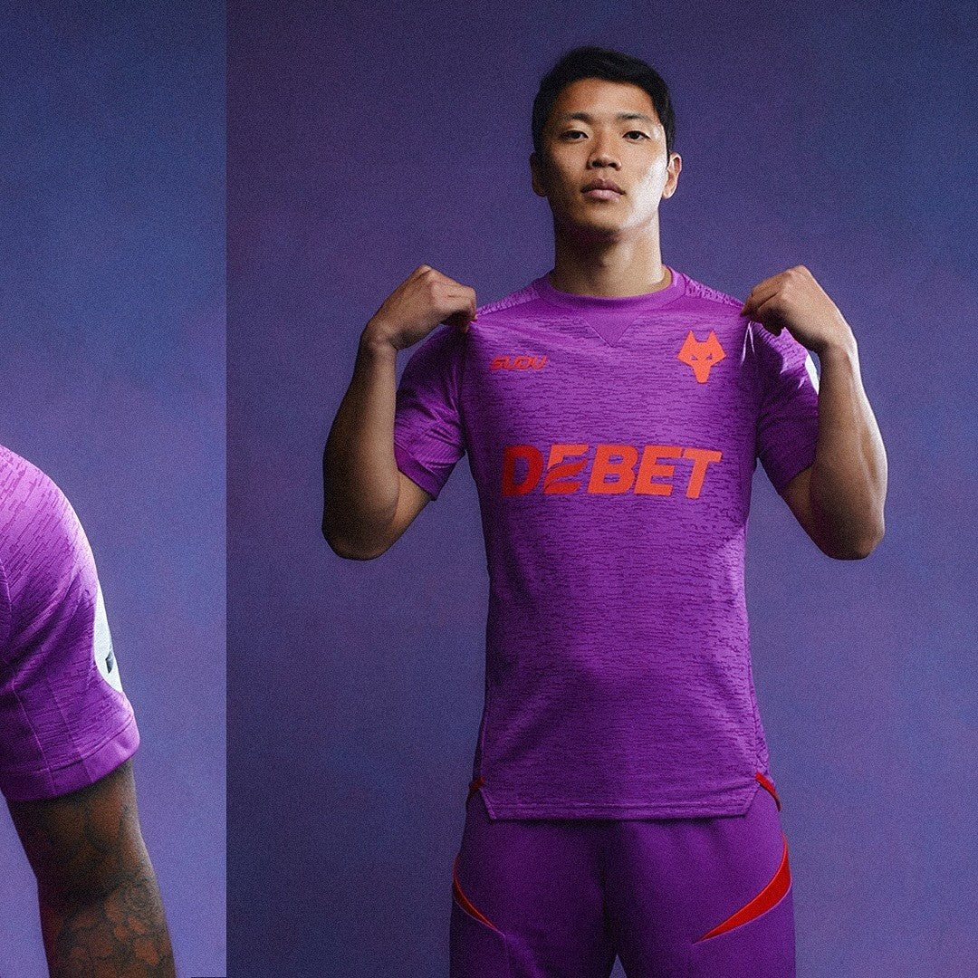 CHe81qFDOtu9oea | AE JERSEY Man in a purple athletic kit adjusting his shirt, logoed with 'DEBET' across the chest, standing against a matching purple backdrop.
