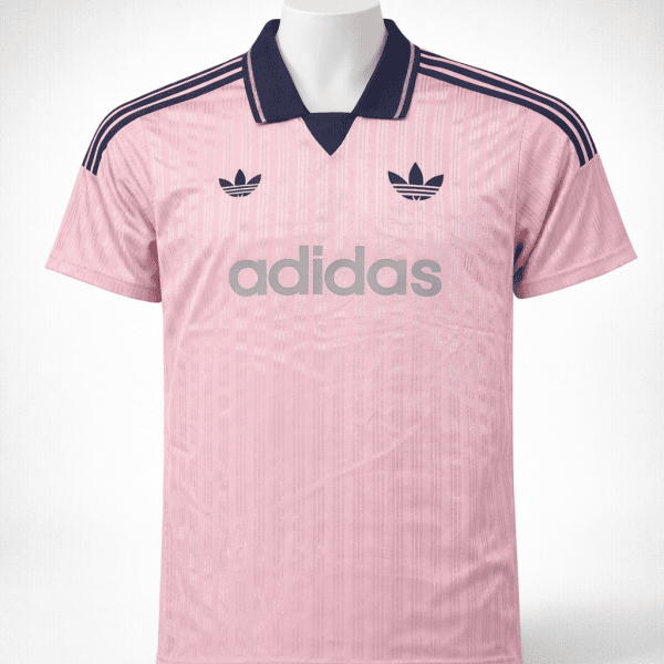 Pink Adidas jersey with navy collar, three navy stripes on shoulders, trefoil logos, and large 'adidas' branding across the chest.
