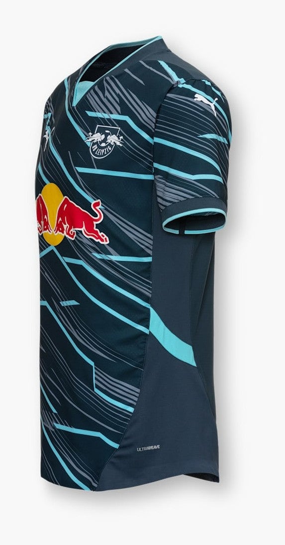 DWnamqCwMbEMTeX | AE JERSEY Dark blue football jersey with light turquoise abstract lines, Red Bull sponsor logo across the front, and a team crest on the chest (side view).