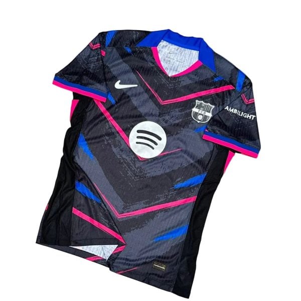 Dark geometric soccer jersey with pink and blue accents, features Nike swoosh, FC Barcelona crest, and Spotify sponsor logo